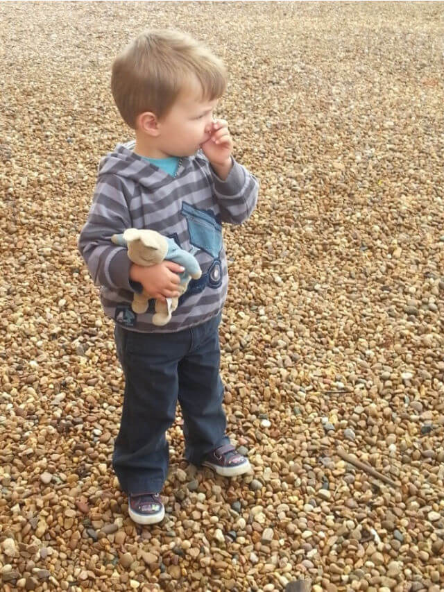 toddler walking holding peter rabbit toy