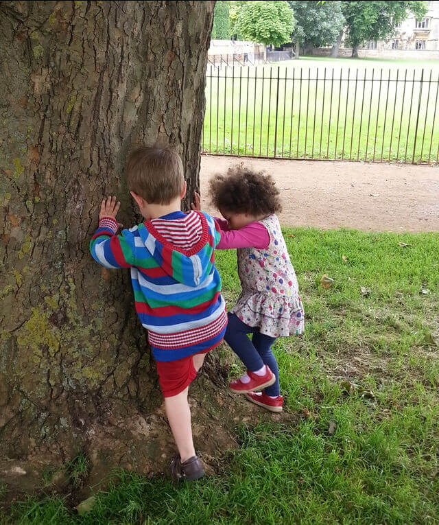 2 toddlers trying-to-climb-a-huge-tree