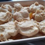 fruit cobbler with raw dough on top ready to cook