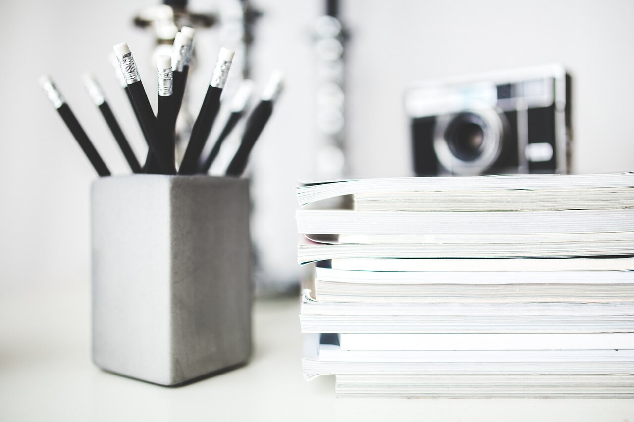 pencils notebooks and camera image in black and white