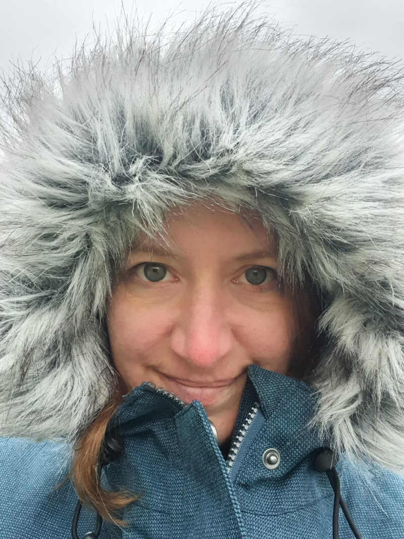 selfie of woman's face surrounded by furry parka hood