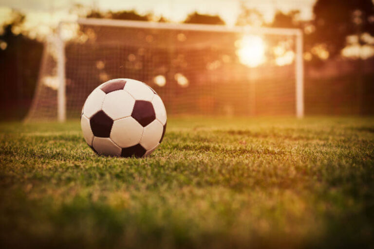 football in sunlit football goal
