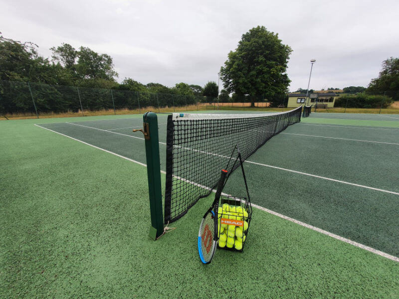 tennis balls and racket ready on court